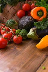 Different vegetables in a basket on a wooden table. Vitamins and health in foods. Healthy food. Free space for text. Copy space