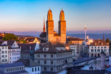 Famous Grossmunster churche along river Limmat at sunset in Old Town of Zurich, the largest city in Switzerland