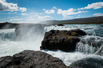 Mighty Godafoss waterfall near Akureyri Iceland on beautiful sunny day with mist hanging in air