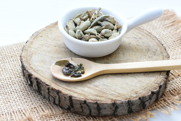 Dry cardamom seed (Elettaria cardamomum) displayed in containers and spoons