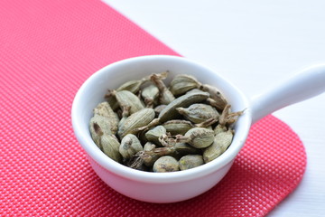 Dry cardamom seed (Elettaria cardamomum) displayed in containers
