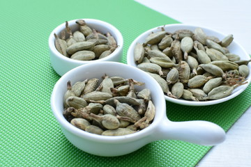 Dry cardamom seed (Elettaria cardamomum) displayed in containers