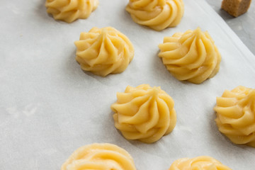 Raw profiteroles on parchment before baking.