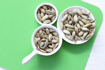 Dry cardamom seed (Elettaria cardamomum) displayed in containers