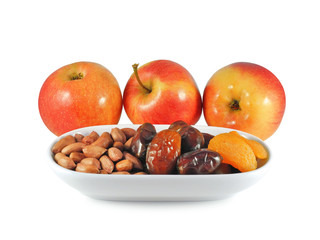 Healthy snack: fresh red apples, dried dates, apricot and raw peanuts isolated on white background....
