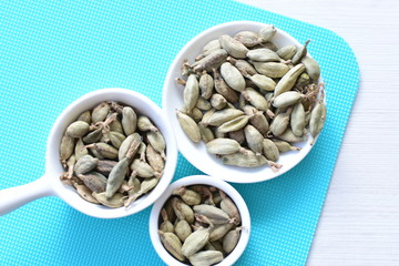 Dry cardamom seed (Elettaria cardamomum) displayed in containers