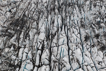 Dirty glacier surface with deep cracks. Aerial drone view of Svinafellsjokull glacier in Iceland