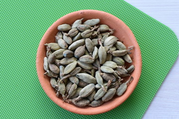 Dry cardamom seed (Elettaria cardamomum) displayed in containers