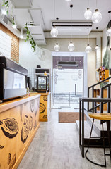 Stylish. Modern interior of cafe.Authentic style with element of loft.Metal and wooden detail.Coffee machine. Green, orange,white and grey colors.