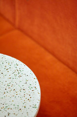 Obraz premium Closeup round white tables and orange sofa.Stylish.Background