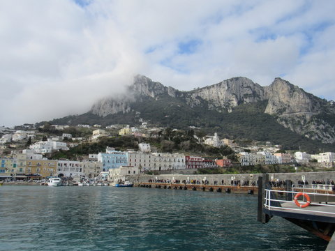 View of the coast and port of Capri, Italy on a sunny but cloudy day 