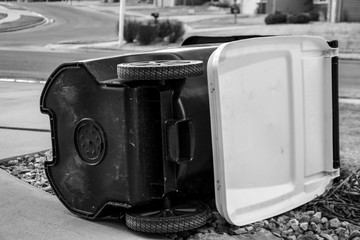 Garbage collection bin blown over by wind in residential area