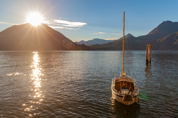 Una barca a vela sulle acque del lago di Como al tramonto 
