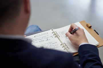 Close-up photo of a hand with a pen of a businessman who writes in a notebook in Russian.