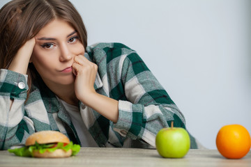 Woman makes a choice between healthy and harmful food