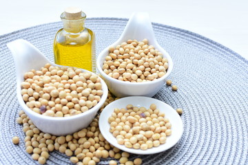 Raw soybeans (Glycine max) displayed in containers and accompanied by oil
