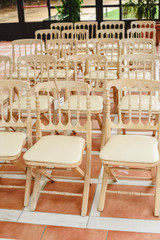 Fototapeta na wymiar Many empty white wooden chairs lined up for a retro style event.