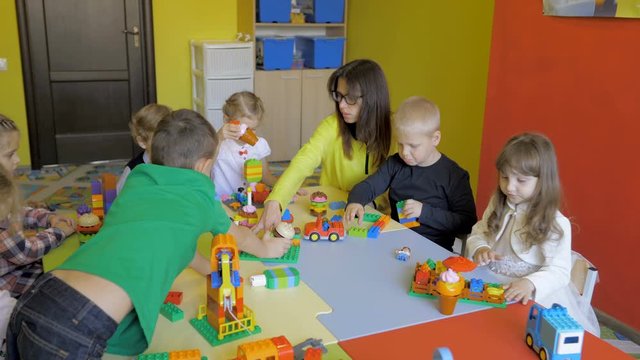 Children in the classroom make figures with teacher. Modern technology concept