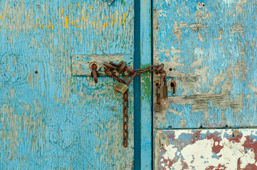 Puerta azul de madera con candado oxidado