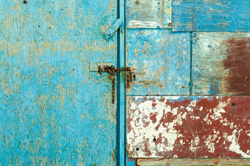 Puerta azul de madera con candado oxidado