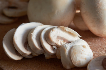 whole and sliced ​​mushrooms, on wooden board, on blue background