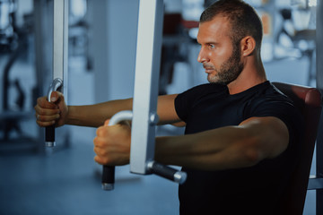 sport, bodybuilding, lifestyle and people concept - young man with barbell flexing muscles and making shoulder and chest press lunge in gym