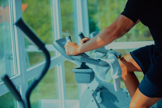 young man riding an exercise bike. The guy is exercising on a stationary bike.