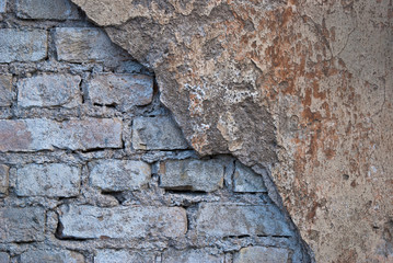 wall of brick with crumbling plaster of gray-brown color , background