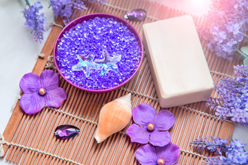 Fototapeta na wymiar Sea salt minerals, some bottles and soap. Lavender and purple color hygiene products and accessories