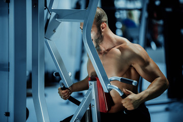 sport, bodybuilding, lifestyle and people concept - young man with barbell flexing muscles and making shoulder and chest press lunge in gym
