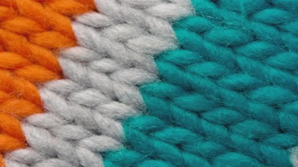 Fibers of knitted clothes with multi-colored threads. Knitted fabric threads macro. Pan to right - Powered by Adobe