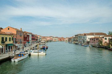 Fototapeta na wymiar Venice, Italy May 18, 2015: View of beautiful canals and boats docked alongside the walkways in Venice Italy