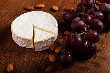 Camembert cheese or brie on wooden background.