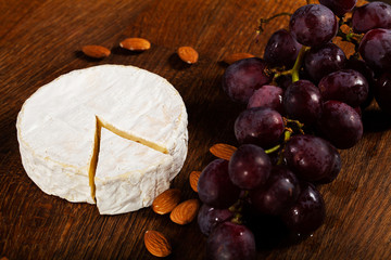 Camembert cheese or brie on wooden background.