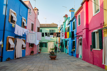 Fototapeta na wymiar Venice, Italy May 18, 2015: Clothes hang dry with colorful houses alongside in Burano Italy