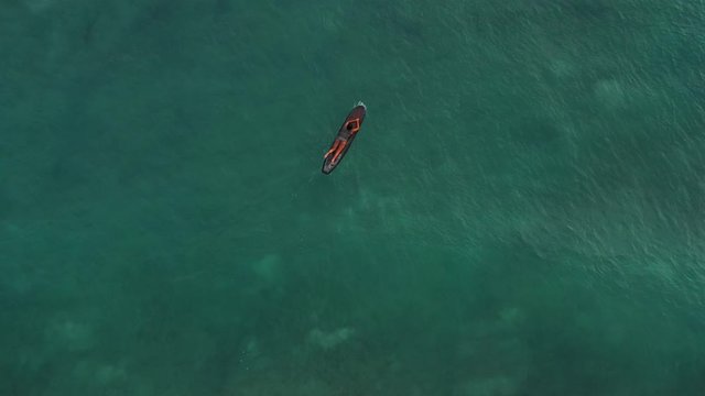 A surfer paddles the waves trying to get further from shore to catch the waves of Waikiki.