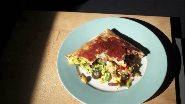 Panning on pocket pizza, comfort food with black background.