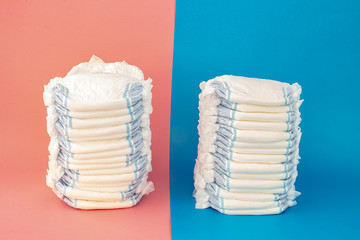 A couple of diapers stack on a blue and pink background