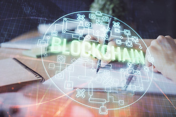 Cryptocurrency hologram, bitcoin, ico theme over hands taking notes background. Concept of...