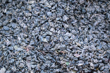 Leaf tea for the background. The dry leaves of the tip tree are crumpled into lumps and twisted into tubules. Slides and pits.