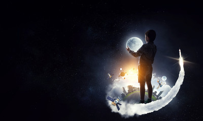 Boy holding moon at night
