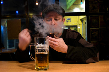 Guy smokes pipe in the bar