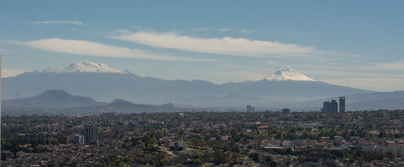 Paisaje urbano de la ciudad de mexico, desde donde se ven los volcanes Iztaciuatl y Popocatepetl
