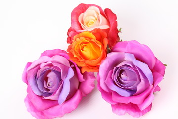 Obraz na płótnie Canvas Artificial violet and red roses on white background