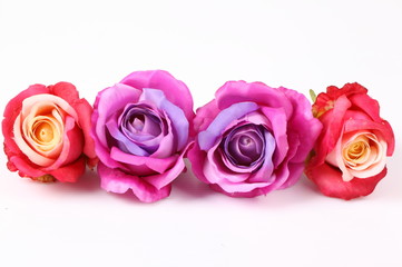 Artificial violet and red roses on white background
