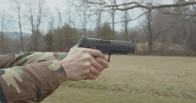 Male shoots a handgun in slow motion