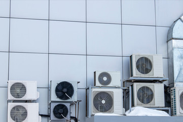 Outdoor air conditioning equipment. Air conditioners are located on the wall of the building.