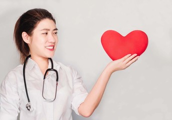 Young beautiful asian doctor woman wore white shirt and Stethoscope, Pointing the big red heart,apple health care and medical concept