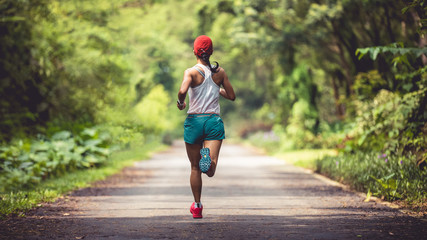 Fitness woman runner running at summer park trail . Healthy fitness woman jogging outdoors.