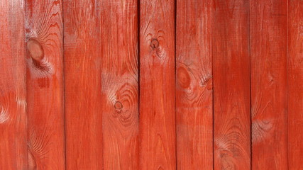 textured lacquered red fence with one highlighted board